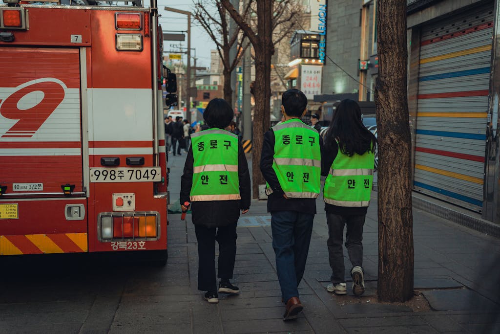 Urban scene in Seoul, South Korea with safety patrols and fire truck during day.